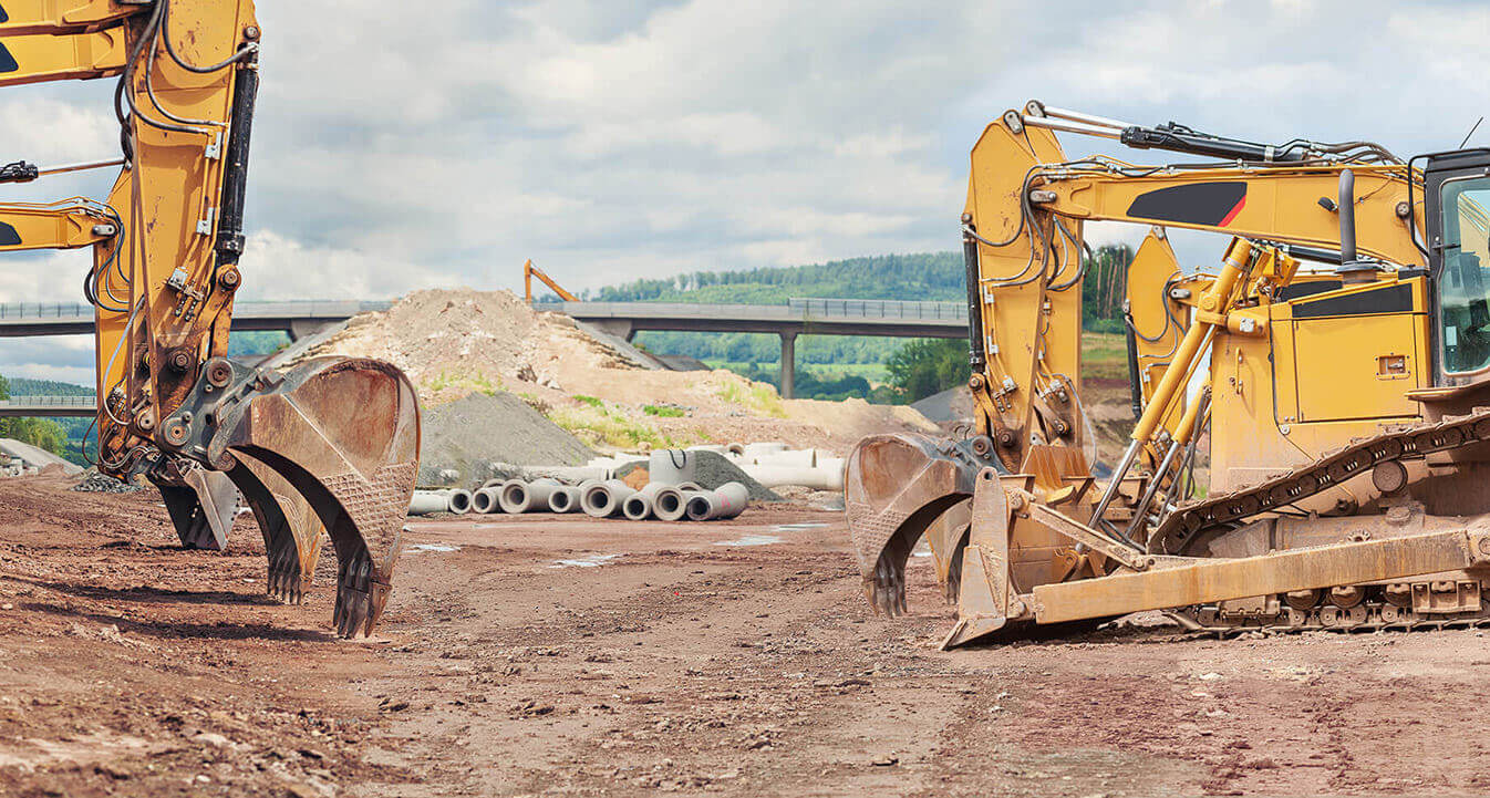 Construction equipment parked in rows at a jobsite